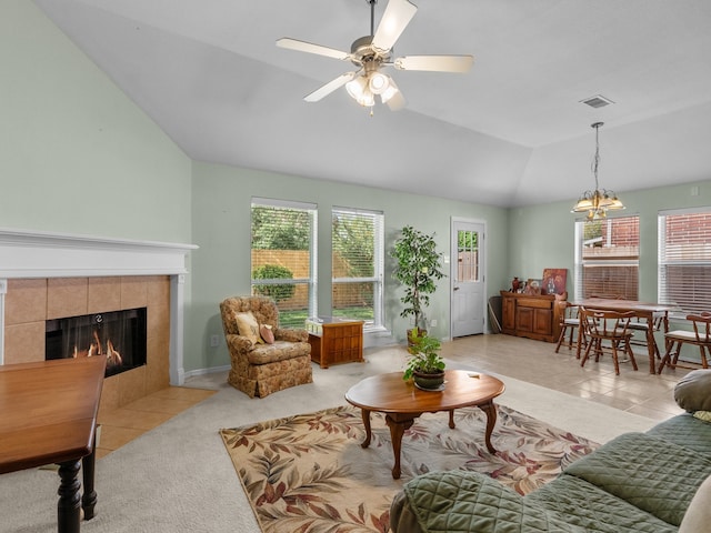 living room with light tile patterned floors, a fireplace, vaulted ceiling, and ceiling fan