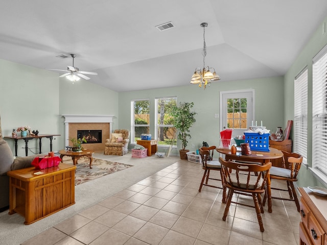 dining area with ceiling fan with notable chandelier, vaulted ceiling, and light carpet