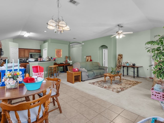 dining area with ceiling fan with notable chandelier and light colored carpet