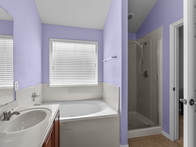 bathroom featuring shower with separate bathtub, vaulted ceiling, vanity, and tile patterned floors