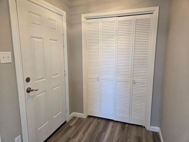 interior space with dark wood-type flooring and baseboards