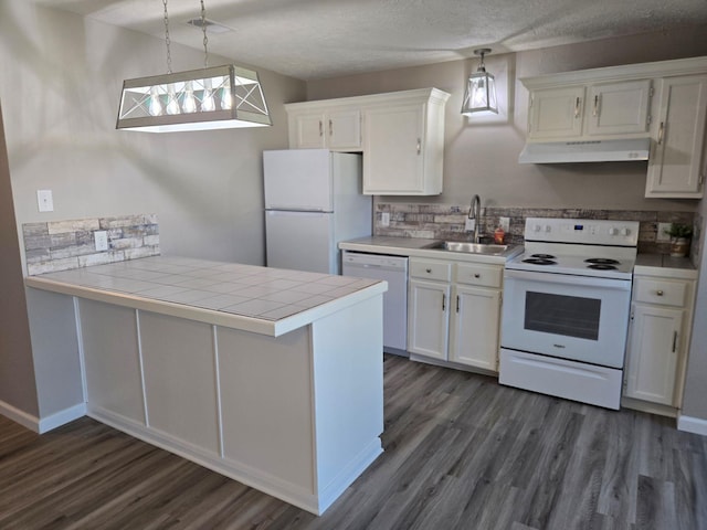 kitchen featuring tile counters, white appliances, a peninsula, under cabinet range hood, and a sink