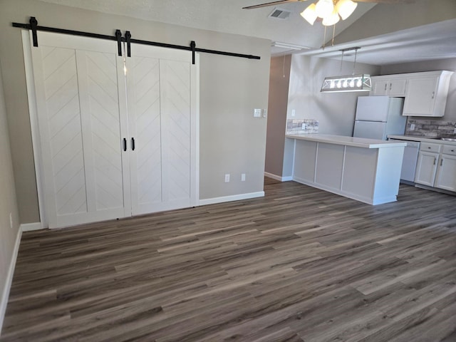 kitchen featuring visible vents, white cabinets, white appliances, and a barn door