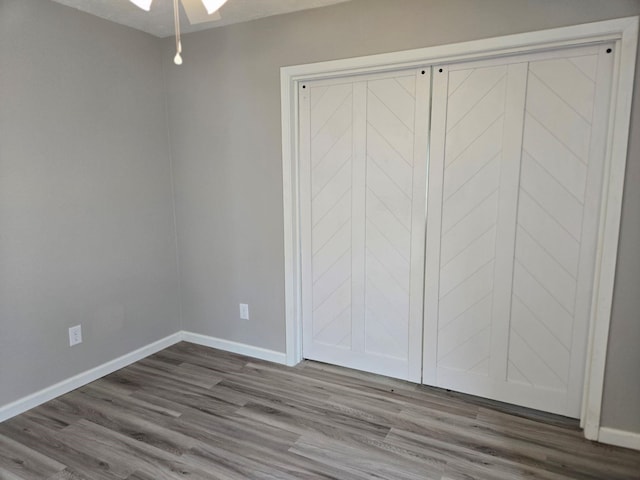 unfurnished bedroom with dark wood-style floors and baseboards