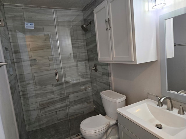 full bathroom featuring toilet, vanity, and a shower stall