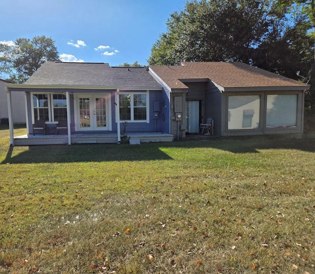 view of front of home featuring a front yard, french doors, and a shingled roof