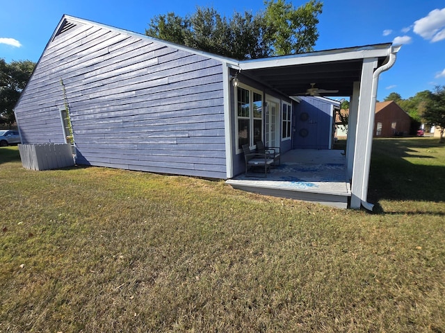 view of property exterior with a patio area, a lawn, and ceiling fan