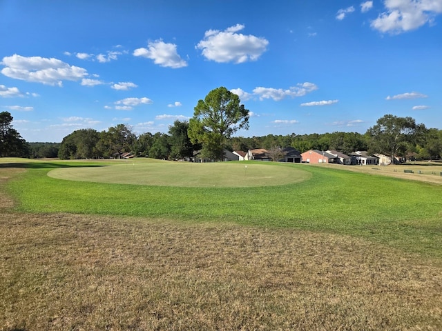view of community with view of golf course and a lawn