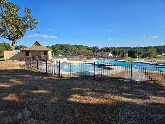 pool with a patio area and fence