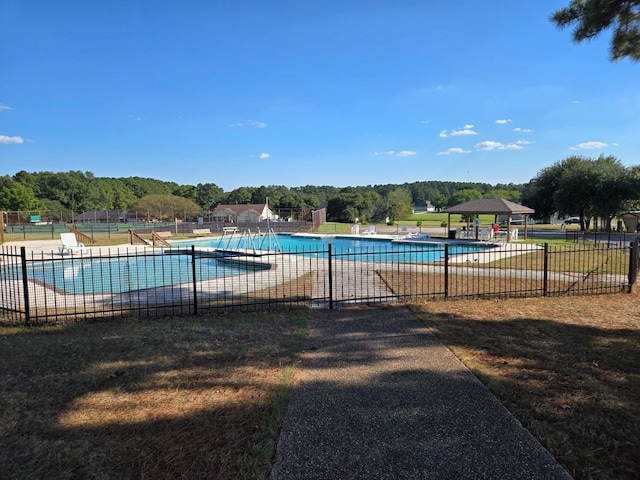 pool with a patio area and fence