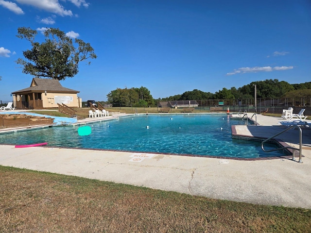 community pool featuring a patio and fence