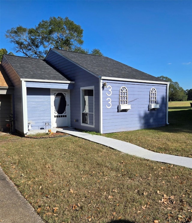 single story home featuring a shingled roof and a front yard