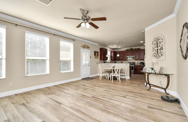 dining room with light hardwood / wood-style flooring, ceiling fan, and ornamental molding