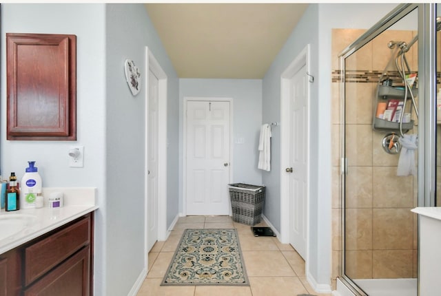 bathroom with tile patterned flooring, a shower with door, and vanity