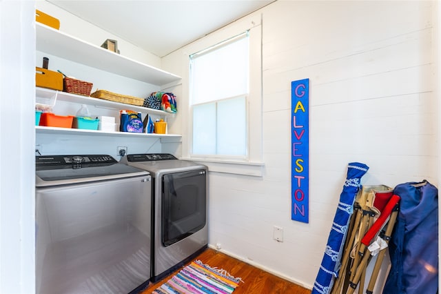 clothes washing area featuring dark wood-type flooring, plenty of natural light, and washer and dryer