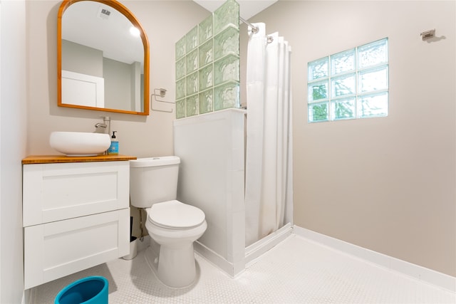 bathroom with toilet, vanity, a shower with shower curtain, and tile patterned floors