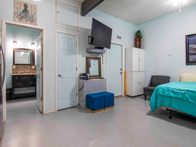 bedroom featuring beamed ceiling and concrete floors