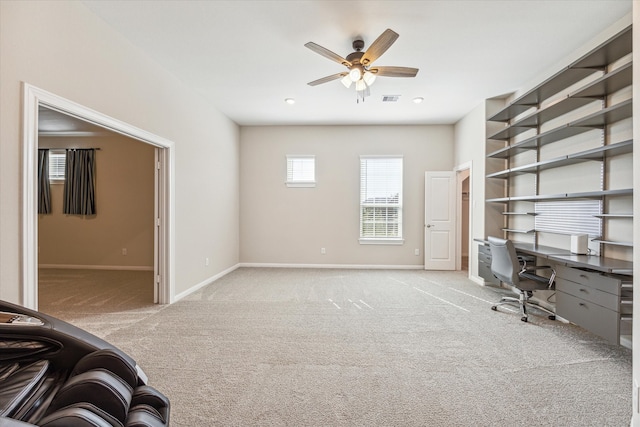 unfurnished office with ceiling fan and light colored carpet