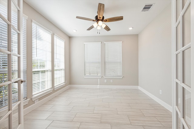 unfurnished room with ceiling fan and a healthy amount of sunlight