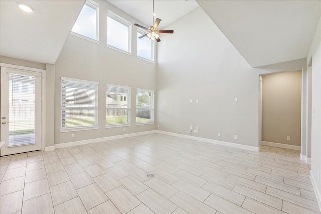 unfurnished living room with ceiling fan and high vaulted ceiling