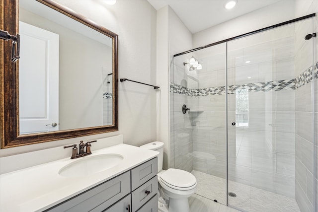 bathroom with vanity, toilet, and a shower with door