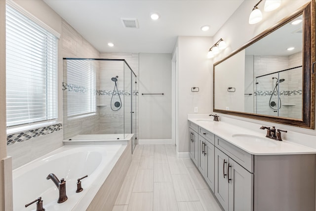 bathroom featuring shower with separate bathtub, vanity, and plenty of natural light