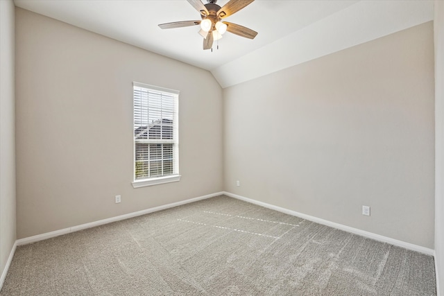 carpeted spare room with ceiling fan and vaulted ceiling