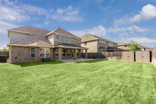 back of house with a lawn, central AC unit, and a patio area