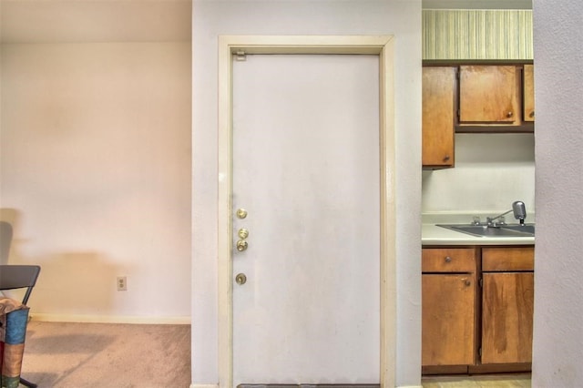 kitchen featuring light carpet and sink