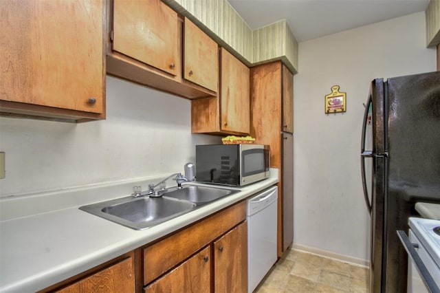 kitchen with white dishwasher, sink, and black refrigerator