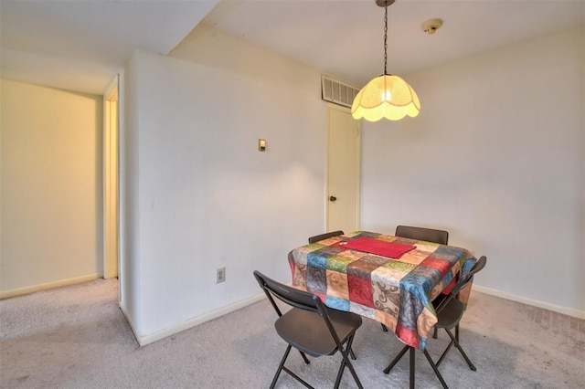 dining space featuring light carpet