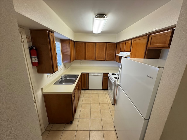 kitchen with light tile patterned floors, white appliances, and sink