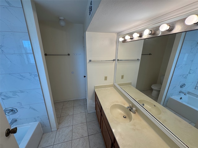 bathroom with a textured ceiling, vanity, tile patterned floors, and toilet