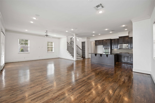 unfurnished living room featuring dark wood-type flooring, ornamental molding, and ceiling fan