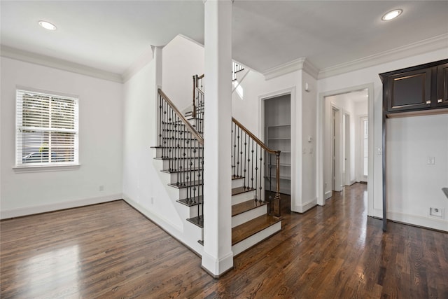 stairway with wood-type flooring and crown molding