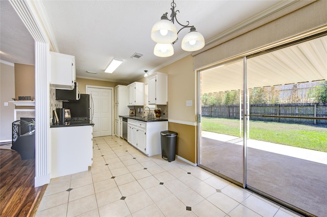 kitchen with hanging light fixtures, appliances with stainless steel finishes, crown molding, and white cabinetry