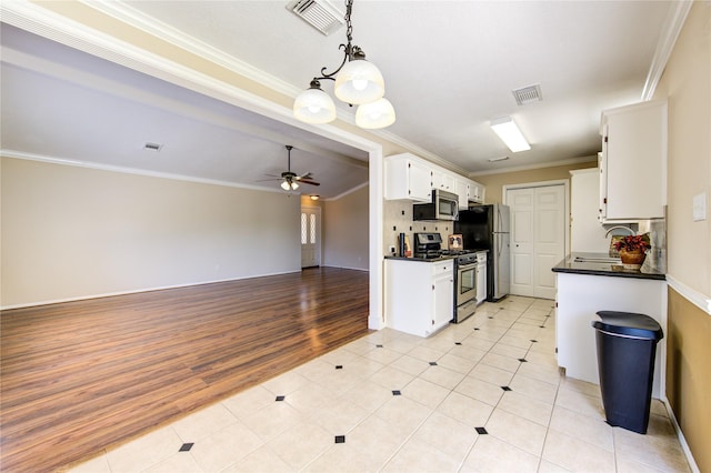 kitchen featuring appliances with stainless steel finishes, white cabinetry, sink, ceiling fan, and crown molding