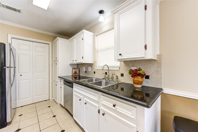 kitchen featuring white cabinetry, stainless steel appliances, sink, backsplash, and light tile patterned floors