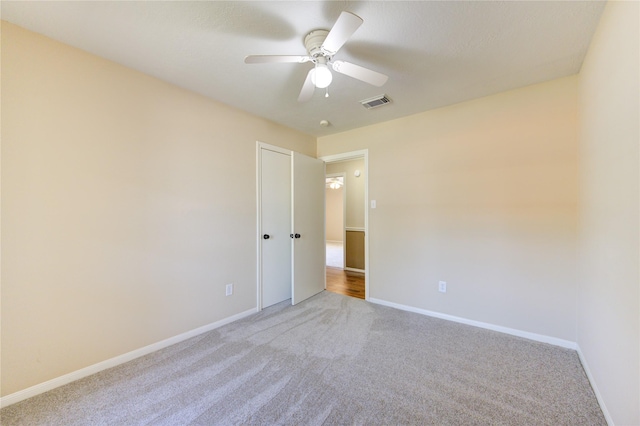 carpeted empty room featuring ceiling fan