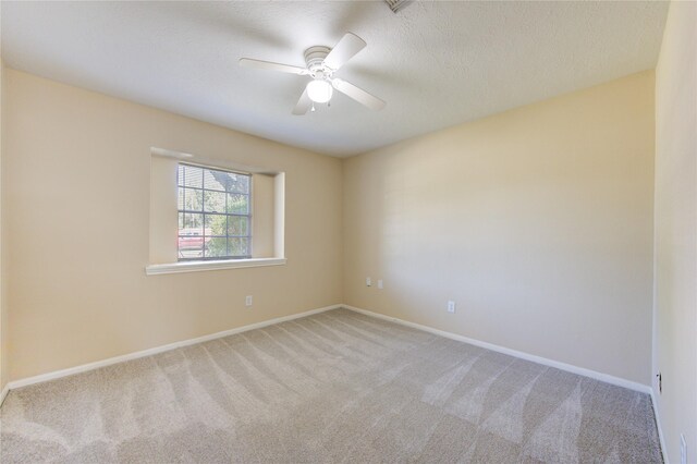 spare room with ceiling fan and light colored carpet