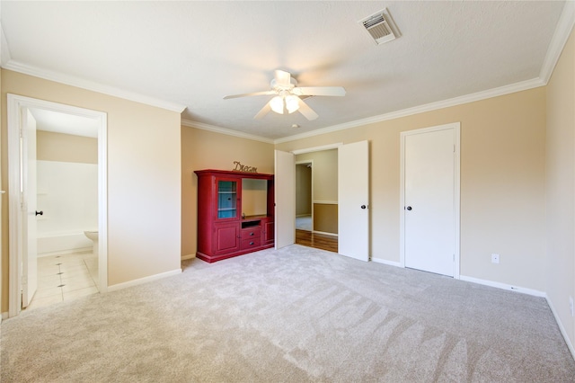 unfurnished bedroom with ceiling fan, ensuite bath, light carpet, and ornamental molding