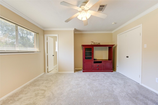 interior space featuring ceiling fan, light colored carpet, a closet, and ornamental molding