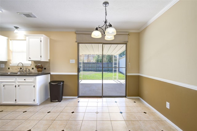 kitchen with pendant lighting, white cabinets, sink, a notable chandelier, and light tile patterned flooring