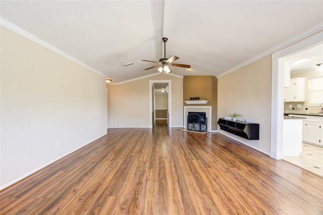 unfurnished living room featuring ceiling fan, hardwood / wood-style floors, a tile fireplace, and crown molding