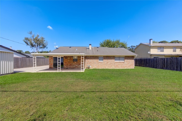 back of house featuring a lawn and a patio