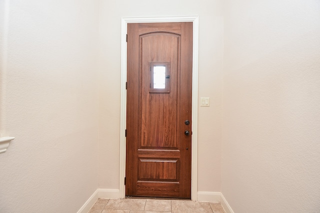 doorway to outside with light tile patterned floors