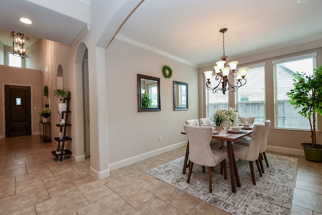 dining space with crown molding and a chandelier