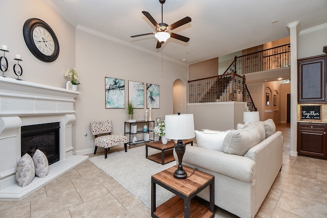 tiled living room with crown molding, a towering ceiling, and ceiling fan