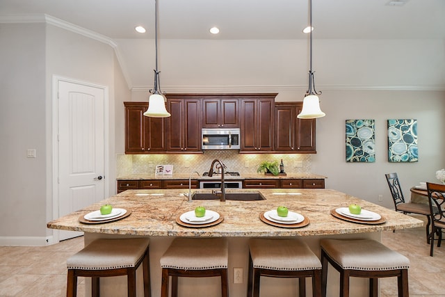 kitchen featuring an island with sink, sink, and a breakfast bar