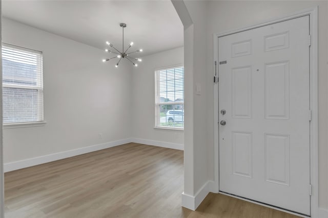 foyer entrance featuring an inviting chandelier and light hardwood / wood-style floors